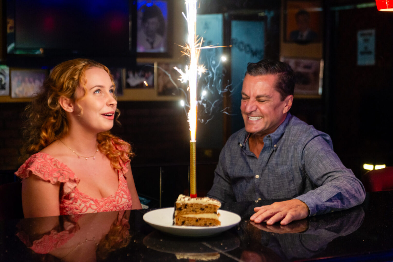 A man and a woman celebrating with sparkles on a cake